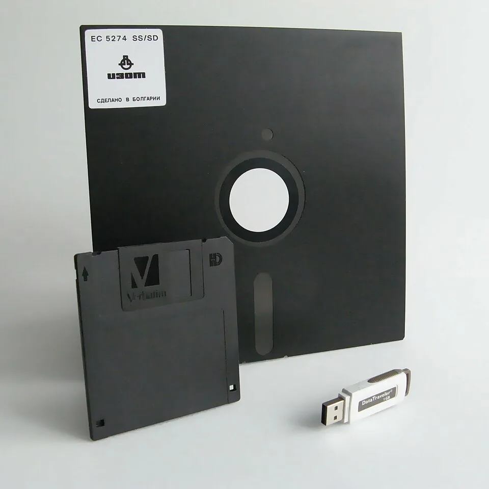 Größenvergleich: 8-Zoll-Diskette neben 3,5-Zoll-Diskette und USB-Stick